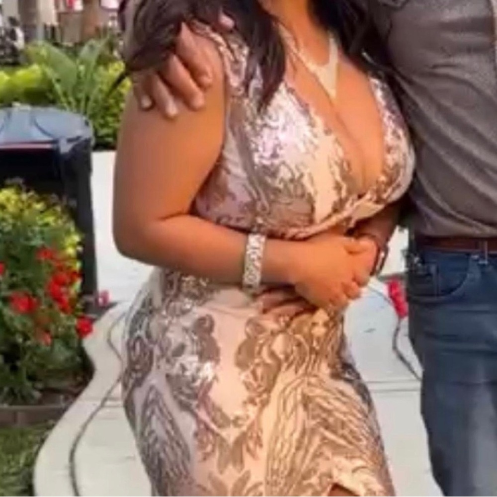 Long rose gold dress with a plunging neck and slit down the middle. Very sexy!